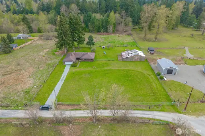 Aerial View of the land stretching all the way back into the trees, where the creek is located. The land between the driveway and neighbor's fence in the top left all belongs to this property.