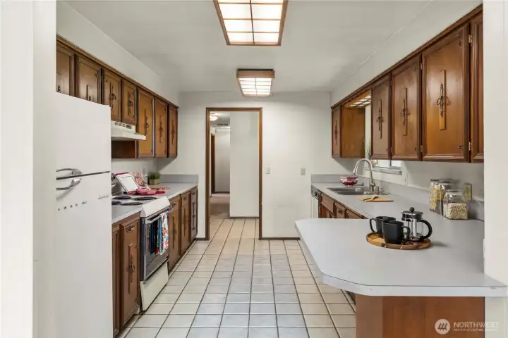 Large kitchen offers a lot of cabinets and counterspace for your cooking needs. Convenient coffee bar at the end.