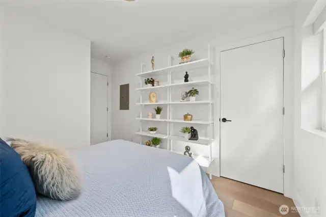 Lower Level Bedroom, with beautiful engineered hardwood flooring, private patio for relaxing with a cup of tea and enjoying nature, built in shelving, spacious room (queen size bed pictured) and large closet