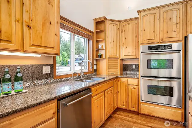 Beautiful cabinetry, slab granite counters, and a double oven combine function and style. The corner appliance garage keeps everyday essentials tucked away—so your kitchen stays clean and clutter-free.