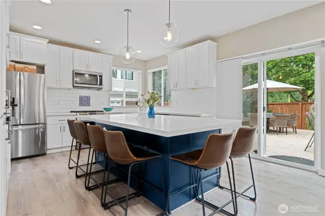 A stunning Italian quartz island invites gathering, with pendant lights that set just the right mood. Sleek stainless steel appliances and a classic subway tile backsplash add both style and ease, while a large sliding door extends the experience outdoors to your own private patio—perfect for morning coffee or evening al fresco dining.