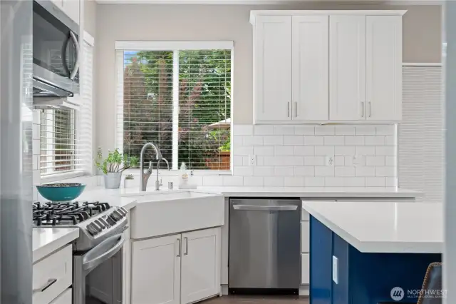 A highly functional kitchen awaits with a premium gas range, spacious farmhouse sink, and a modern stainless steel dishwasher.