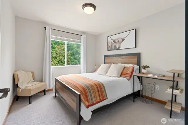 This bedroom features a large window, making it ideal for a home office or guest room.