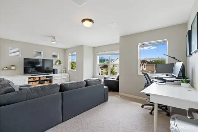 The upstairs living area is a spacious and bright space, with numerous windows and loads of storage, creating an open and airy feel.