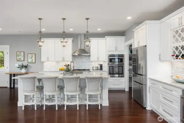 Stunning gourmet kitchen with stone counters, tile backsplash, and all stainless appliances