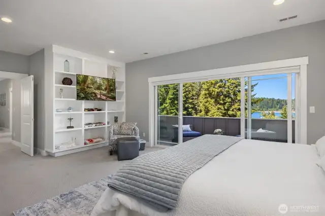 Substantial Primary suite with private covered deck, an attached TV above custom built shelves, and an ensuite bath.
