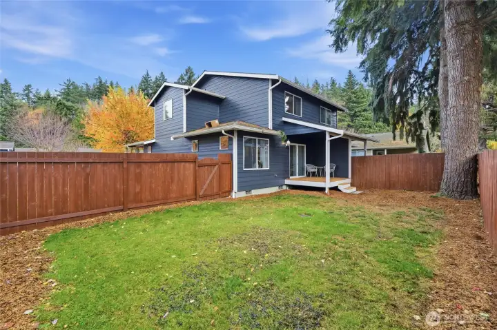 Fully fenced large backyard with cozy covered back deck.