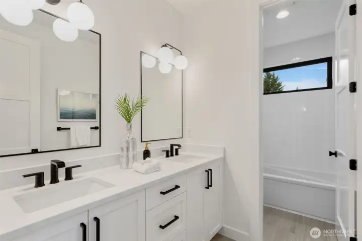 Upper level bathroom with double sinks and bathtub on the upper floor