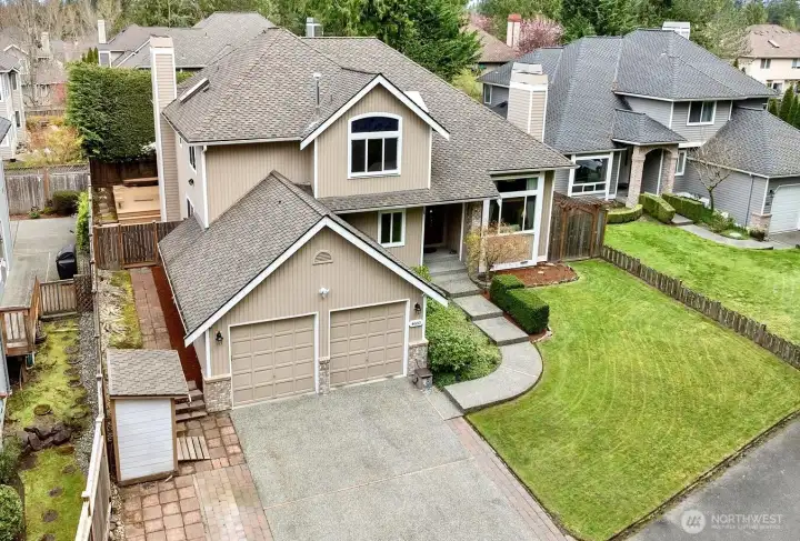 Stunning aerial view showcasing the home’s inviting curb appeal, beautifully landscaped yard, and extended driveway offering parking for 3 vehicles.