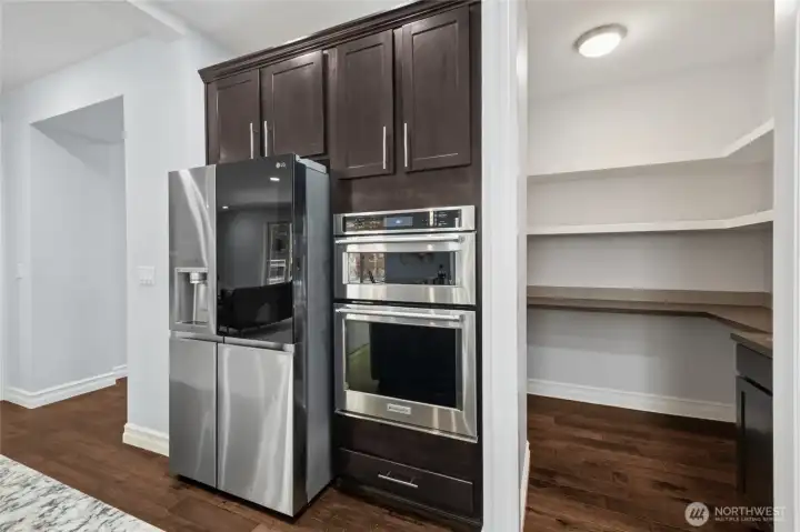 Modern LG refrigerator featuring a glass-view door and craft ice maker, combining innovation and style. Thoughtfully designed with an additional wall oven and microwave, making cooking and hosting easy and efficient.
