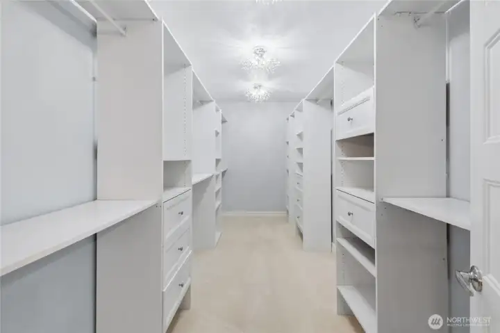 Huge walk-in closet featuring abundant shelving and drawers for the finest wardrobe organization across every season.