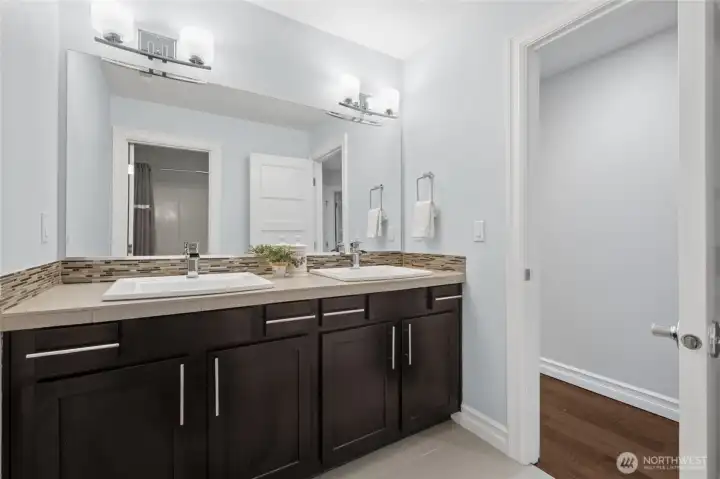 Hall bath features smart separation between the double vanity and the shower/toilet room for enhanced privacy and functionality.