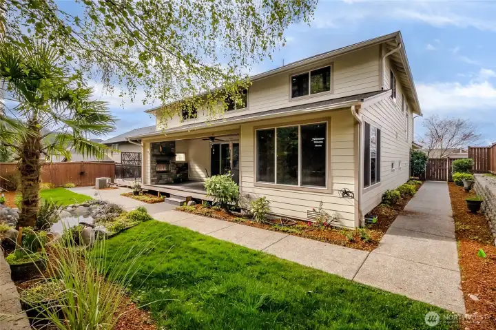 Rear exterior view of the home with a centrally located covered deck and the separate apartment deck on the far side.