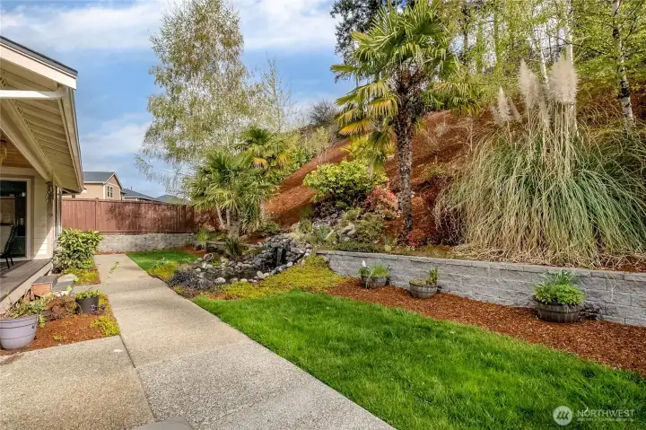 Resort-inspired backyard offering palm trees, a koi pond, and a waterfall, creating a truly private and calming oasis.