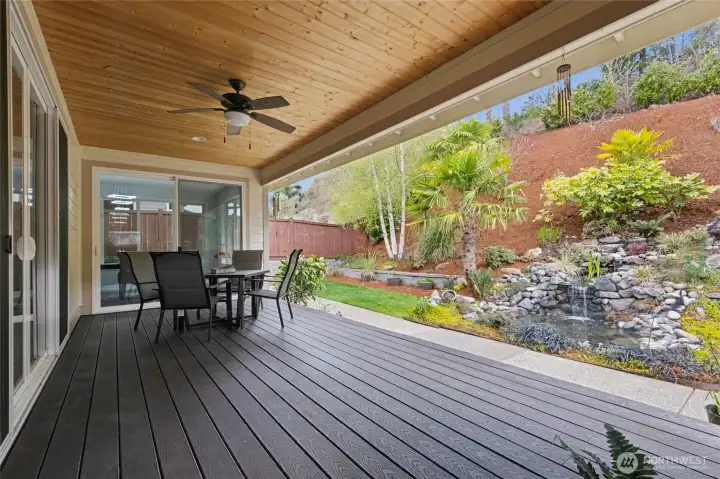 The deck offers beautiful views of the lush, landscaped backyard and calming water features.