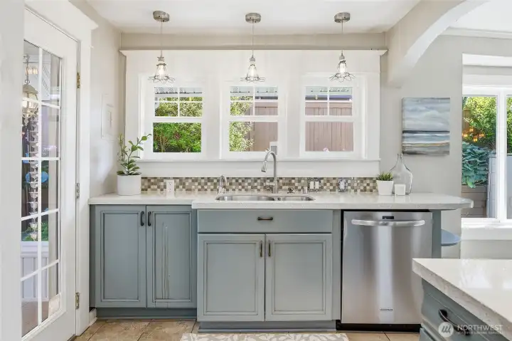 South side of kitchen with door leading to magical backyard.  Walls of windows let in all the natural light!