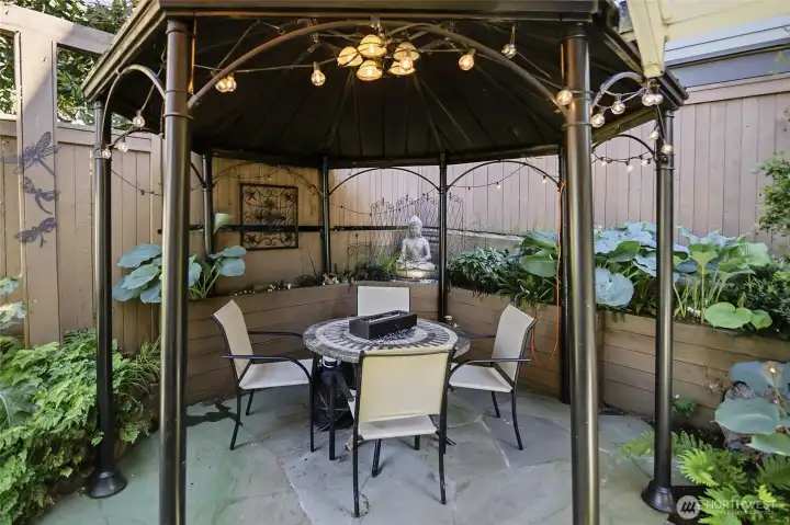 Gazebo in backyard stays and allows al fresco dining in festive surroundings with plush greenery!