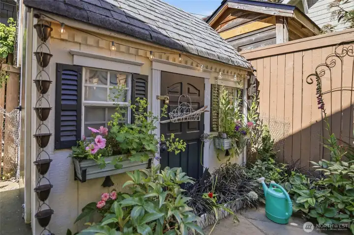 Adorable shed for cute storage to match the home!  Great storage, cute flower boxes, rain chain and shutters!  Enchanting!