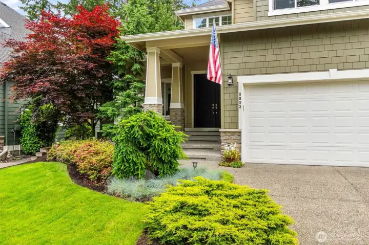 Lovely PNW landscaping is highlighted by the stone accents and stately covered front entry.