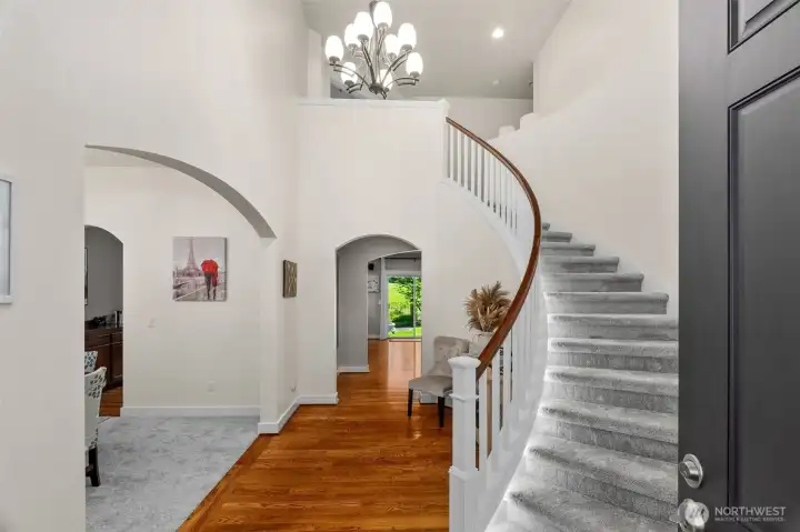 Stunning vaulted entry with curved, lit staircase, brand new carpet, and rich hardwood floors set the stage for a home experience you'll love!
