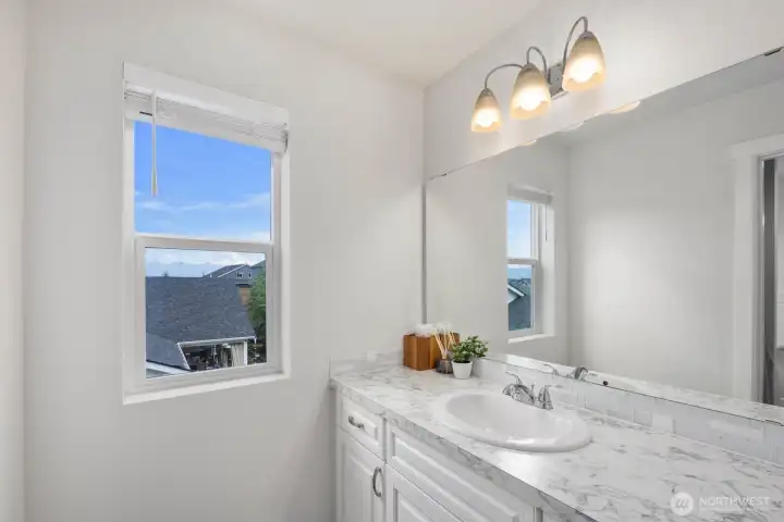 This bathroom feels fresh and functional, with natural light, a spacious vanity, and simple finishes that keep the space feeling open.