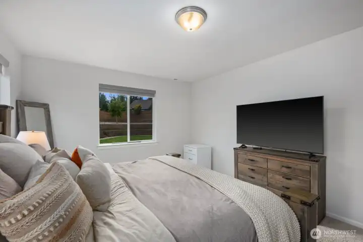 The primary suite feels spacious and serene, offering a comfortable retreat with plenty of room to relax and recharge.