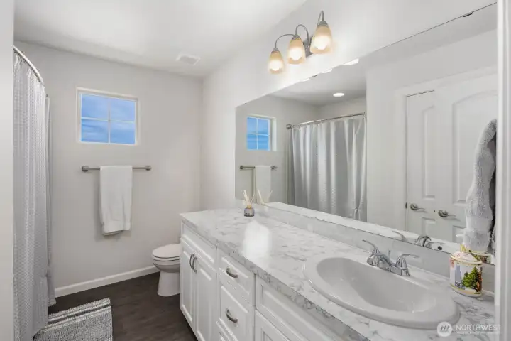 This full bathroom features a spacious vanity, generous counter space, and timeless finishes that balance style and functionality.
