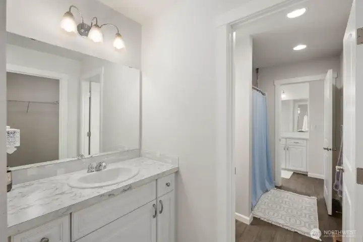 Bright lighting, ample storage, and a spacious vanity create a bathroom designed for both busy mornings and relaxed routines.