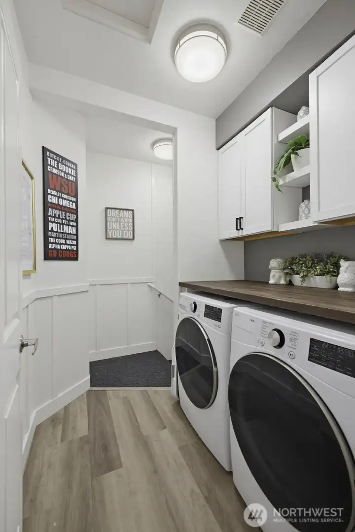 Laundry with cabinets and the stairs to the garage