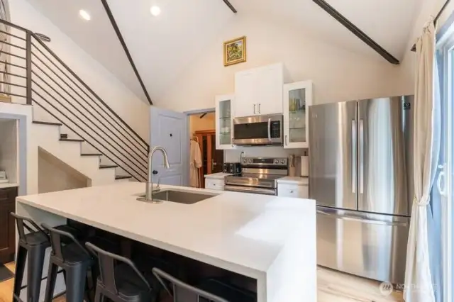 Cottage (Airbnb) Kitchen is light, bright and modern with quartz countertops, and an open concept, stainless steel appliances, a deep sink, expansive island