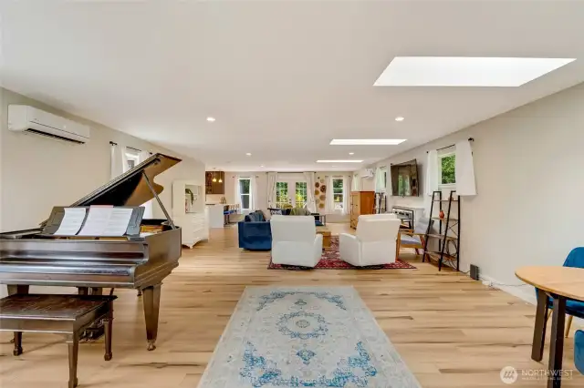 bright, open floor plan with abundant natural light streaming through large windows. The living space features new luxury vinyl plank (LVP) flooring throughout, adding warmth and durability with a modern touch.