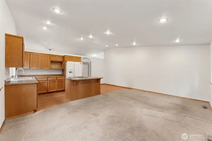This view shows the heart of the home in action. The family room and kitchen share the vaulted space, giving the area an easy flow and plenty of light. Off to the side, the hardwood zone creates a natural place for a breakfast table, work nook, or hobby corner without crowding the main seating area. It’s a flexible pocket of space that lets the home adjust to your routine instead of the other way around.
