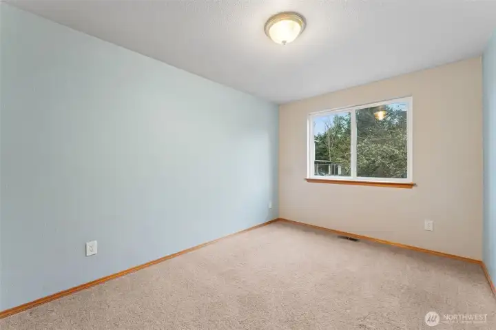 Bedroom #2 keeps things easy and comfortable. Soft blue walls pair with a creamy accent wall and bright white ceiling, so it already has a calm, relaxed vibe without locking anyone into a specific style. The large window brings in great natural light, and the carpet keeps it cozy for guests, hobbies, or everyday use. Located in the North Thurston School District, it works nicely for a bedroom, office, or whatever life needs next.