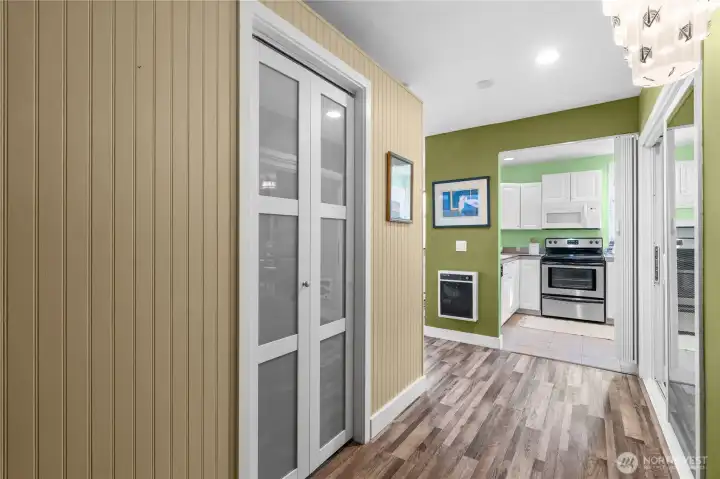 Foyer inside unit - glass paneled door to the left is a storage closet - kitchen is ahead - bedroom to the right - living area to the left