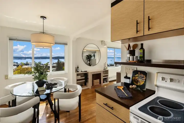 Kitchen detail — updated cabinetry with textured fronts, dark countertops, stainless sink, dishwasher, and full-size refrigerator. The galley layout is efficient and well-organized, with generous upper and lower cabinet storage throughout.
