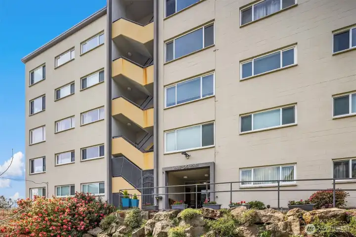 Classic mid-century architecture perched above the city, surrounded by mature landscaping and sweeping views.