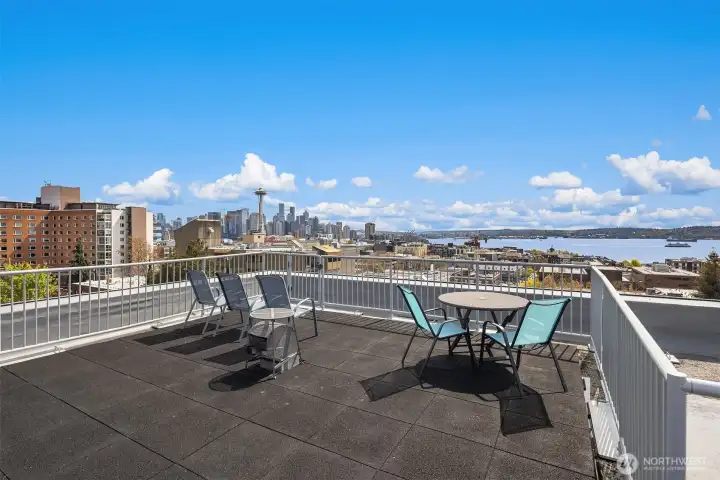 Expansive rooftop deck with panoramic Seattle skyline, Elliott Bay, and Space Needle views—your front-row seat to sunsets and city lights.