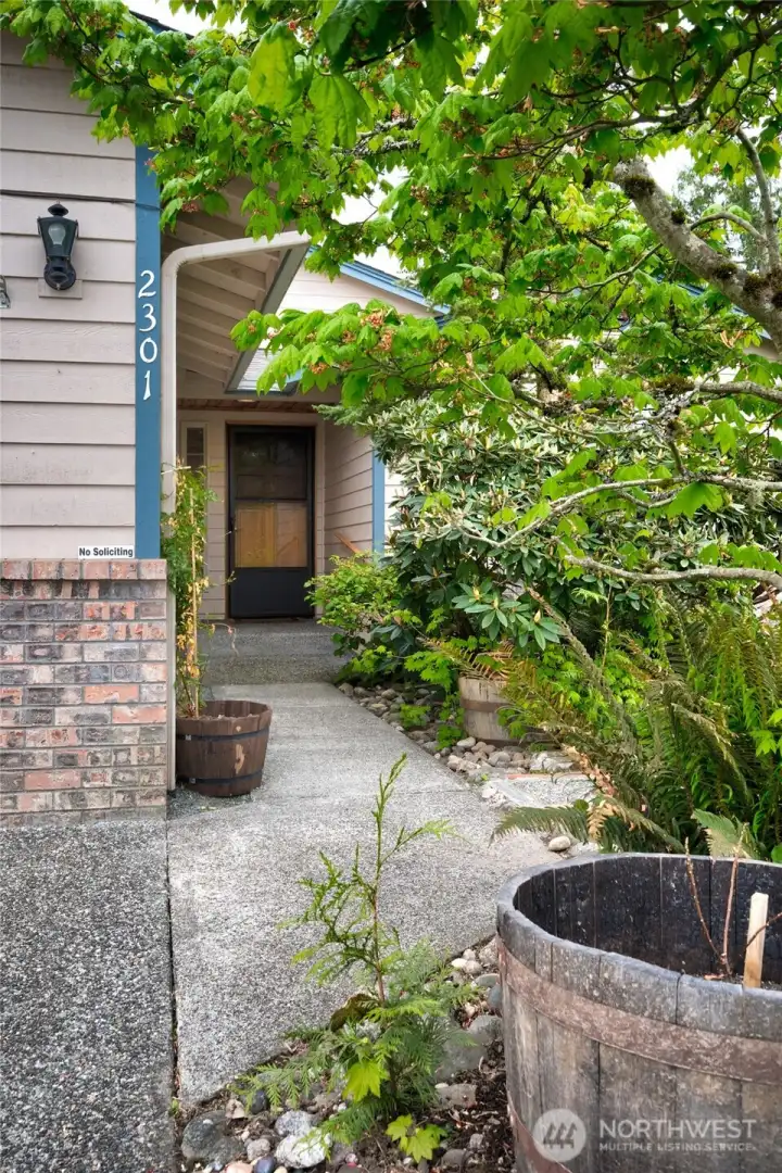 A beautiful exposed aggregate walkway leads to the main entrance.