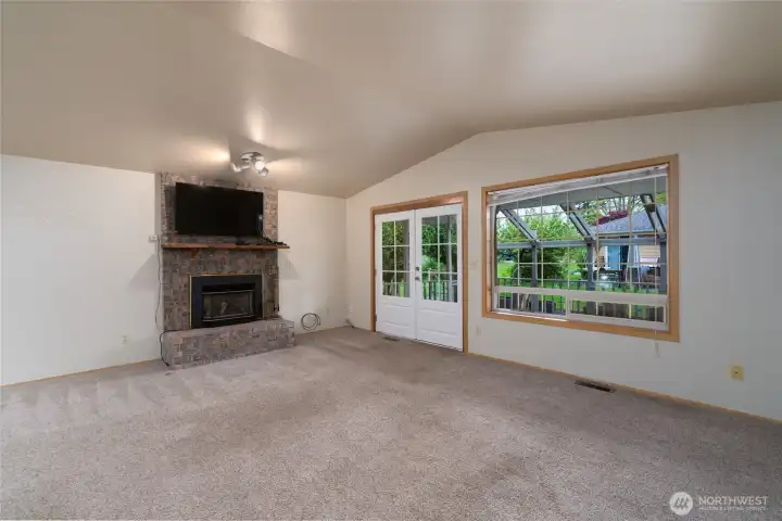 The living room features a gas fireplace and French doors that open to the covered patio.