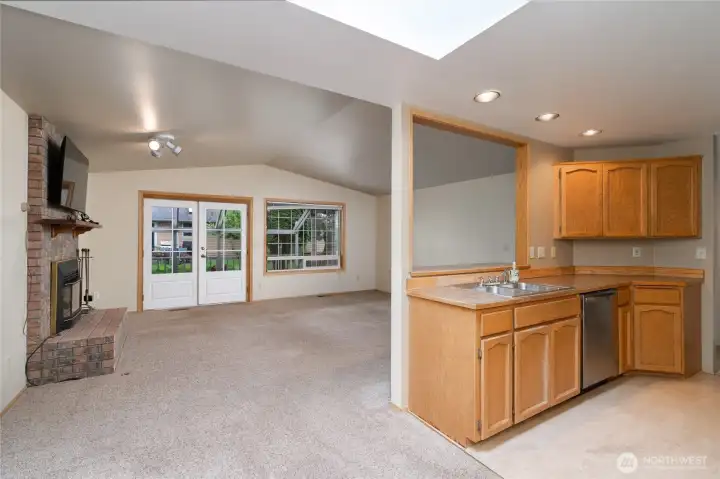 From kitchen/dining area - gas fireplace and French doors to the patio and fenced yard.