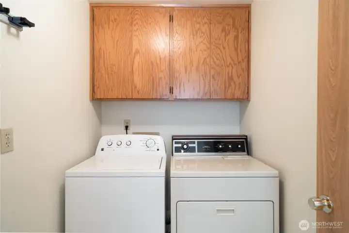 Laundry room immediately on the right as you enter from the garage, with full-size washer and dryer and extra storage.