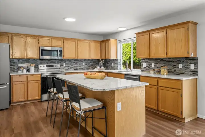 The spacious eat-in kitchen features elegant quartz countertops, abundant workspace, and room for casual dining.