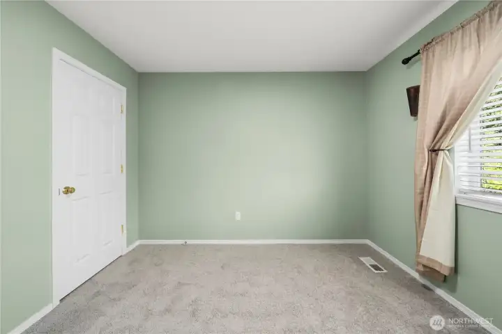 Another view of the spacious upstairs bedroom, showcasing its generous layout and abundant natural light.