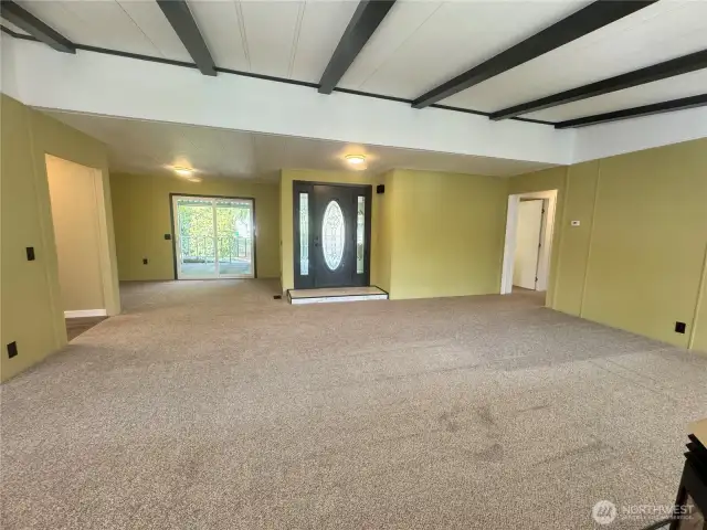 This is the living room, with its beautiful front door and door-side windows. To the left is the dining room's patio door, leading out to the deck and waterfront.