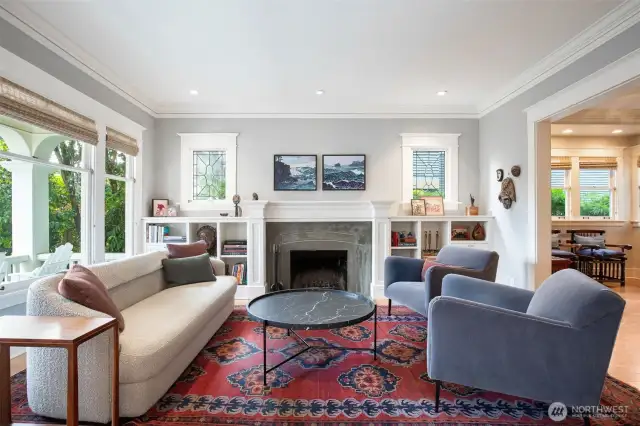 The living room with a custom fireplace surround and shelves for books, mementos and photos.