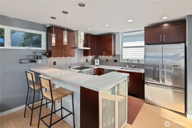 Sleek kitchen with Bertazzoni range, stainless appliances, and lots of natural light.