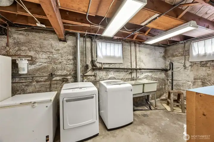Basement laundry area with utility sink. All appliances convey with the home.