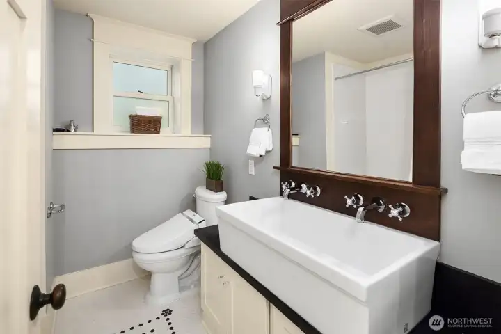 The farmhouse sink anchors the space—clean, substantial, and paired with finishes that keep the look of this lower level full bath simple and elevated. The farmhouse sink anchors the space—clean, substantial, and paired with finishes that keep the look of this lower level full bath simple and elevated.