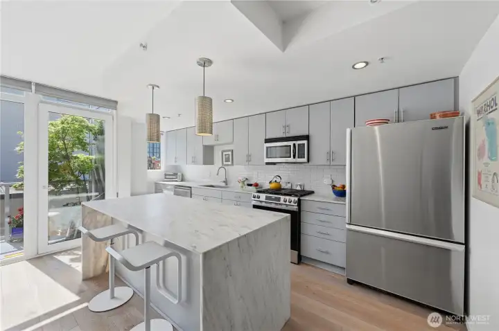 Stunning kitchen with lots of cabinet & drawer storage, new stainless steel dishwasher & gas range oven plus this gorgeous marble waterfall island. Stunning kitchen with lots of cabinet & drawer storage, new stainless steel dishwasher & gas range oven plus this gorgeous marble waterfall island.