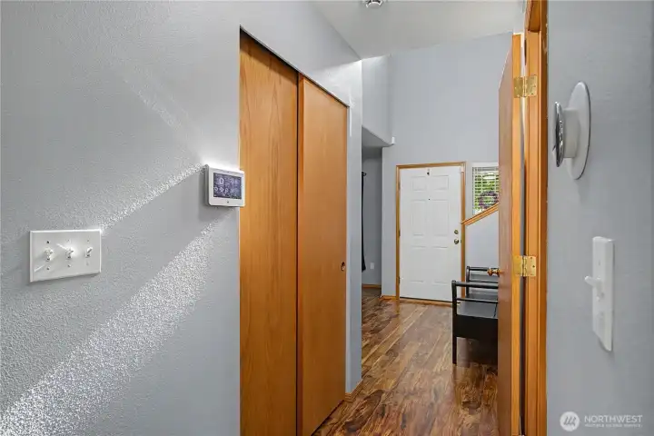 Hall from kitchen/living room to half bath on the right and coat closet off to the left